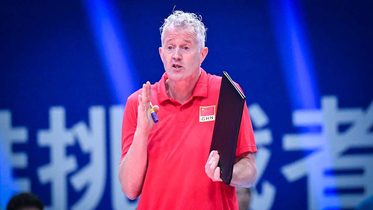 Stefan Heynen, trener siatkówki, trzyma czarną tabliczkę i mówi do dziennikarza.