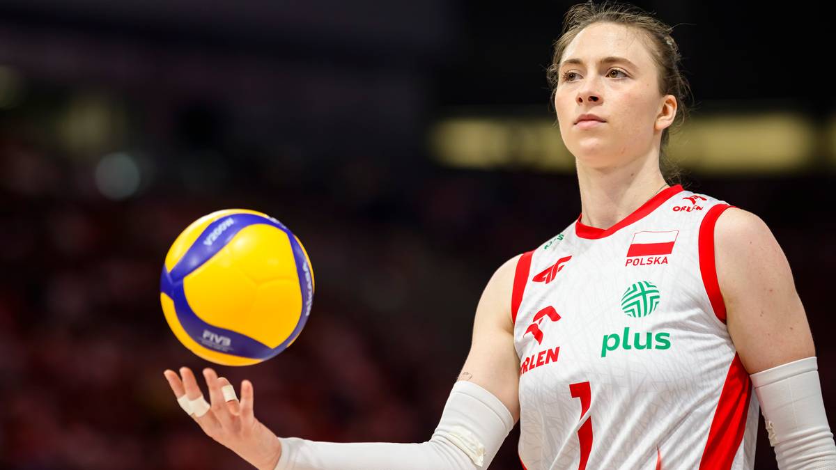 Kobieta trzymająca piłkę do siatkówki, przygotowująca się do zagrywki.
