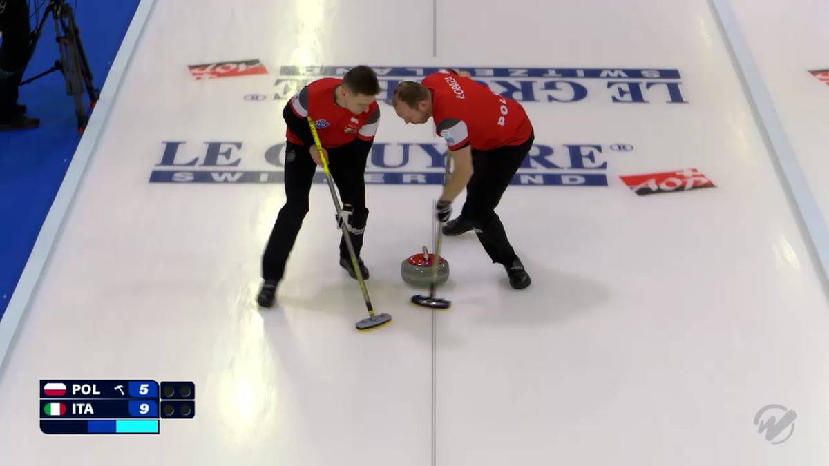 Dwóch graczy curlingowych w czerwonych strojach, jeden zamiata lód, drugi przygotowuje się do rzutu.