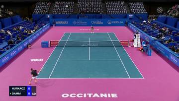 Mecz tenisa ziemnego Huberta Hurkacza z Martinem Damem Jr. na korcie z r&oacute;żową nawierzchnią i niebieskimi bandami. Widownia zasiada na niebieskich trybunach.