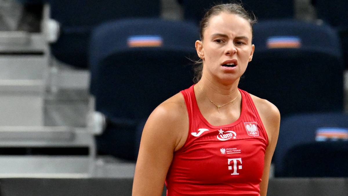 Portret Magdy Linette w czerwonej koszulce tenisowej, patrzącej z determinacją.