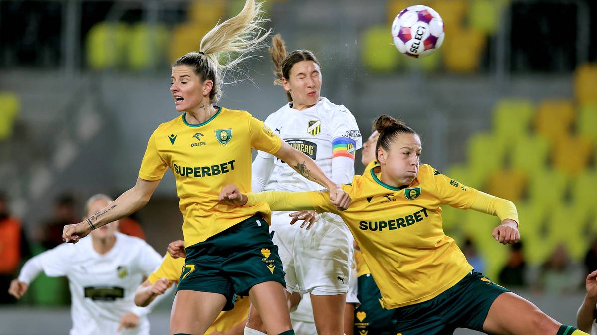 Dwie zawodniczki piłki nożnej w żółtych strojach walczą o piłkę w powietrzu.