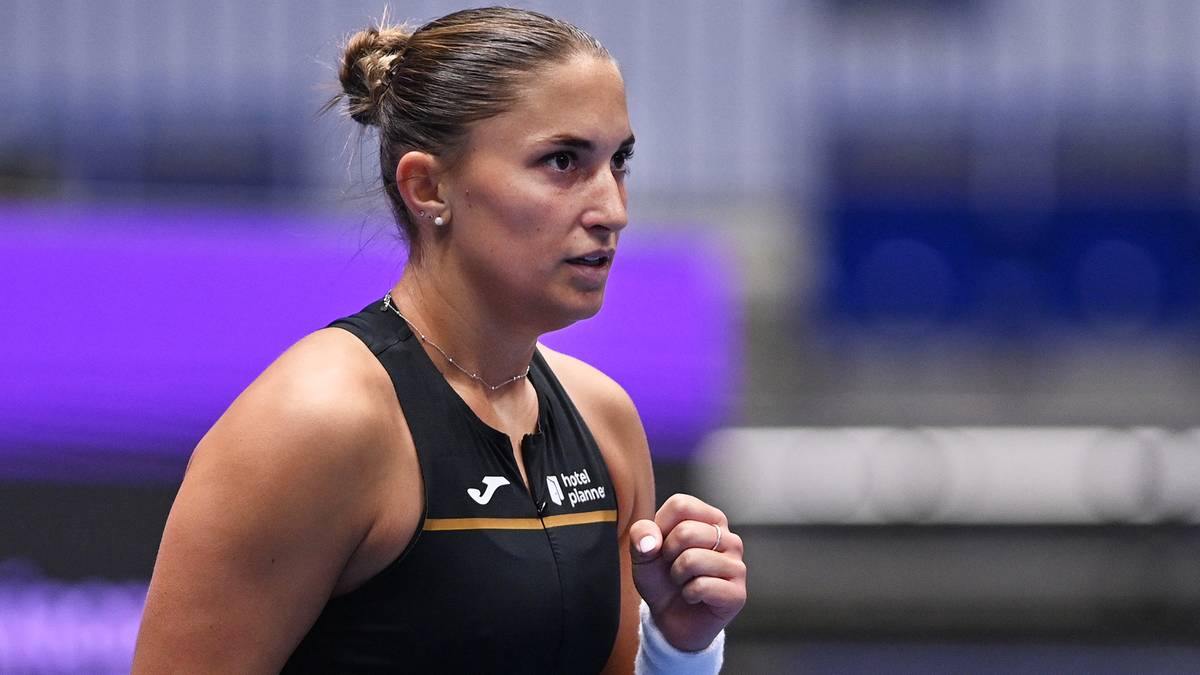 Portret tenisistki Marie Bouzkovej w czarnym stroju sportowym, z zaciśniętą pięścią, patrzącej w bok