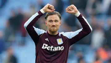 Piłkarz Aston Villi, Matty Cash, z uniesionymi rękami w geście radości.