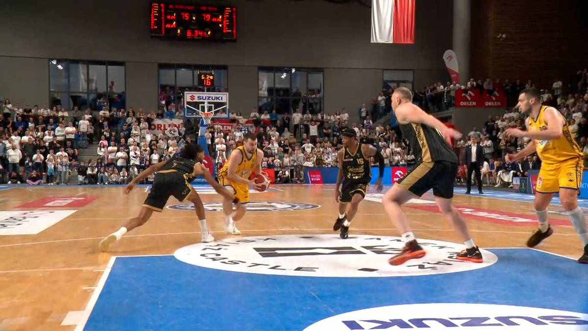 Gracze drużyn koszykarskich rywalizują o piłkę na boisku podczas meczu w hali sportowej.