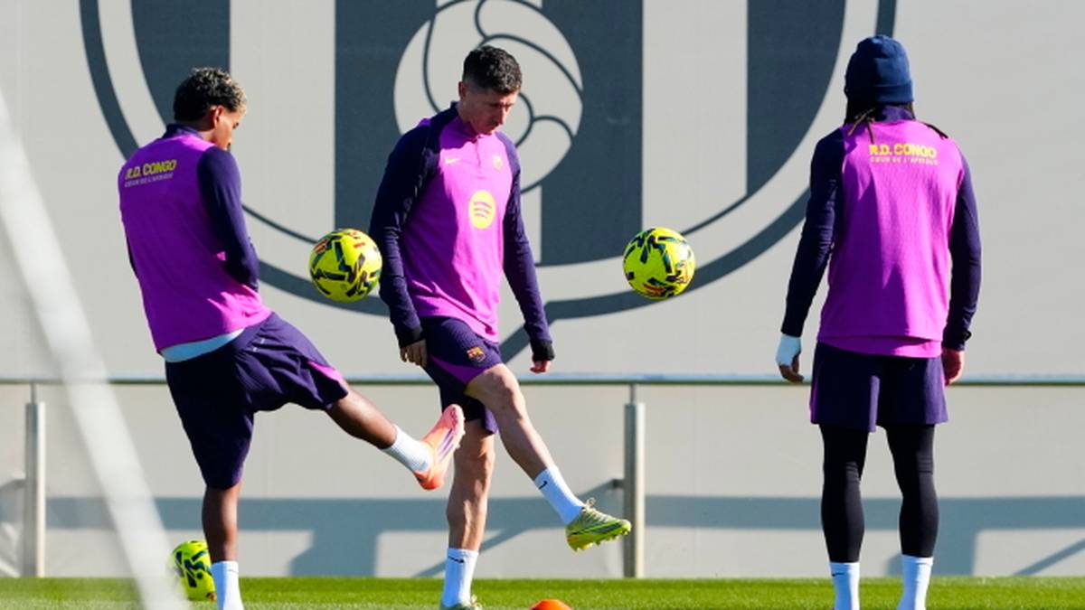 Trzech piłkarzy w różowych strojach treningowych ćwiczy z piłkami na boisku.