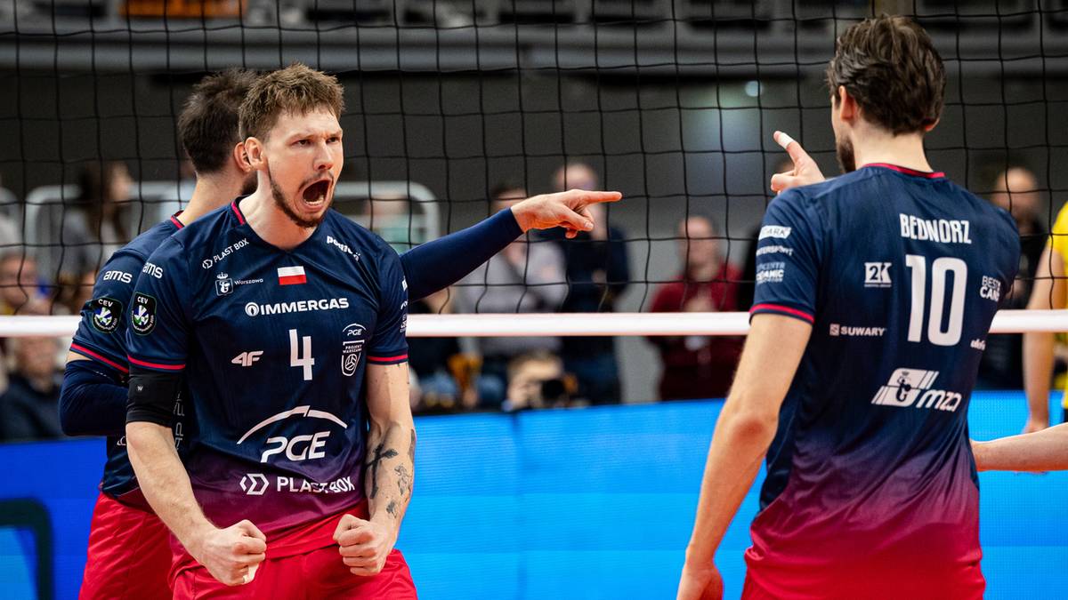 Siatkarz w koszulce z numerem 4 krzyczy z radości, a obok niego stoi kolega z numerem 10 podczas meczu siatk&oacute;wki.