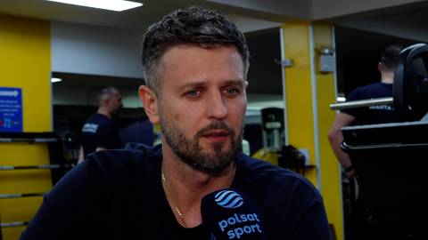 Portret Michała Winiarskiego, siatkarza, z mikrofonem Polsat Sport przed twarzą.