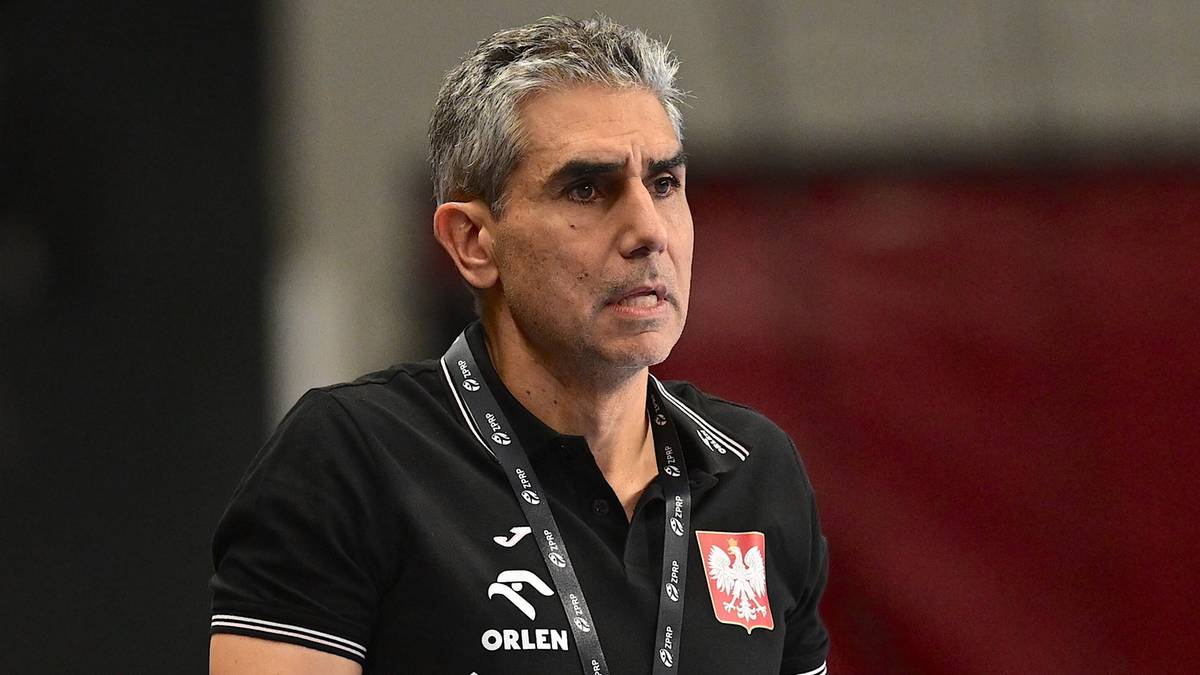 Trener piłki ręcznej w czarnej koszulce z godłem Polski na rękawie