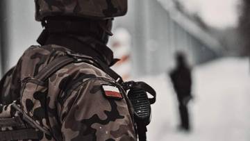 Żołnierz Wojska Polskiego w mundurze z naszywką polskiej flagi na ramieniu.