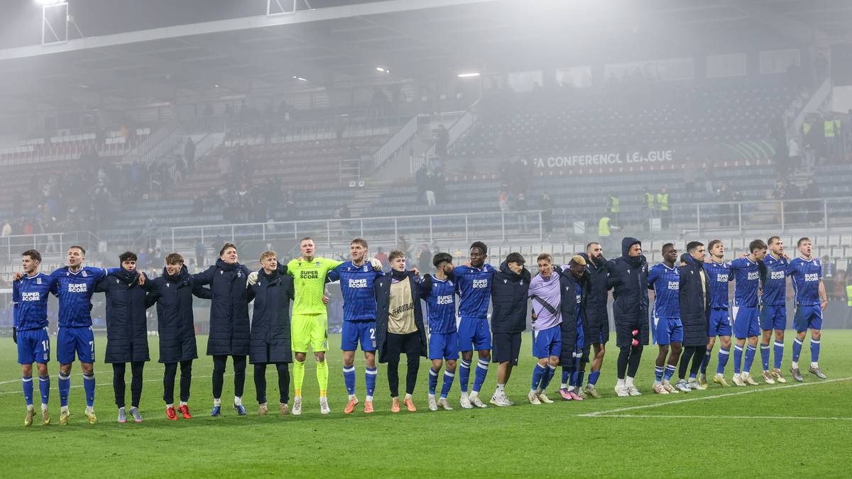 Drużyna piłkarska Lecha Poznań pozuje do zdjęcia na boisku po wygranym meczu.