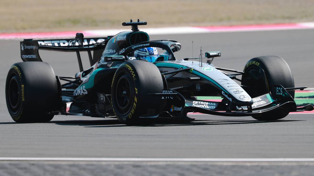 Samoch&oacute;d Formuły 1 w kolorach zielonym i czarnym na torze wyścigowym.