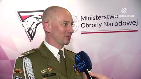 Mężczyzna w mundurze wojskowym z przypinkami, mówi do mikrofonu. Za nim znajduje się logo Ministerstwa Obrony Narodowej.