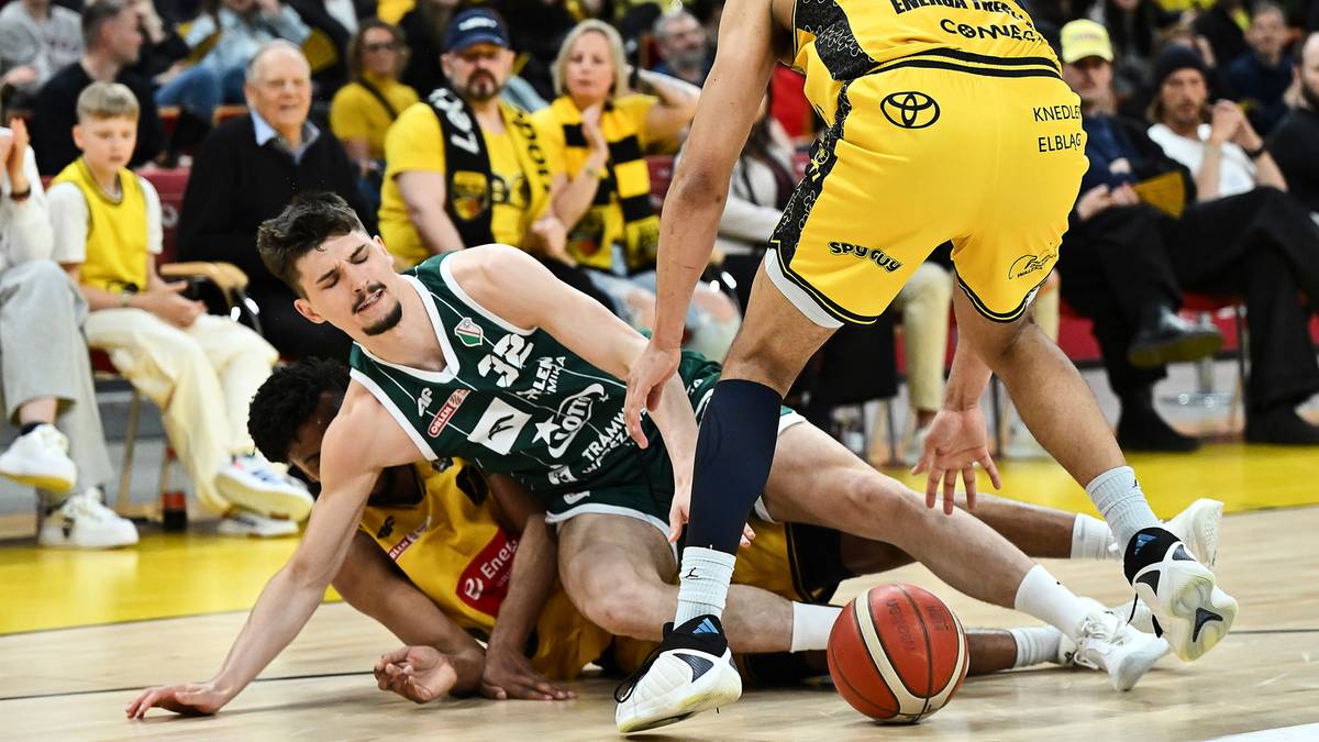 Koszykarze walczący o piłkę na parkiecie podczas meczu.