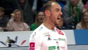 Siatkarz Moritz Karlitzek w białej koszulce krzyczy podczas meczu, z publicznością w tle.