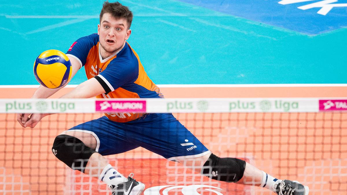 Siatkarz w akcji, wykonujący odbicie piłki w pozycji leżącej.