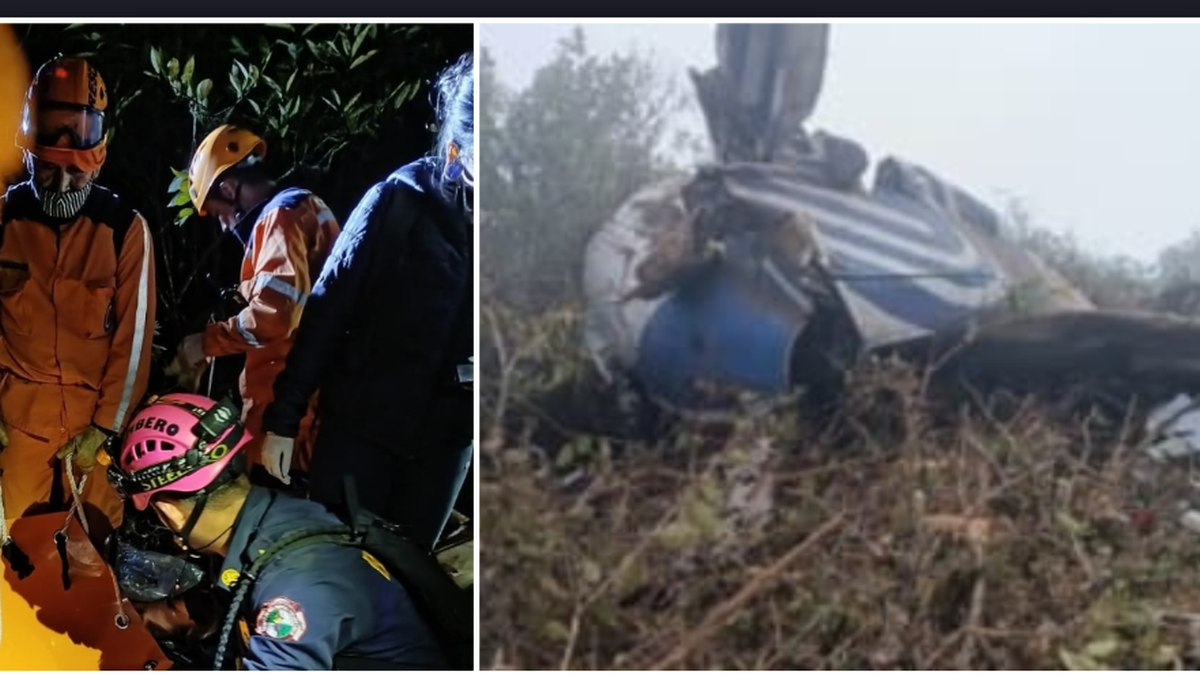 Grupa ratownik&oacute;w w pomarańczowych kombinezonach i kaskach pracująca nocą na miejscu wypadku po lewej stronie, a po prawej stronie widać szczątki rozbitego samolotu.