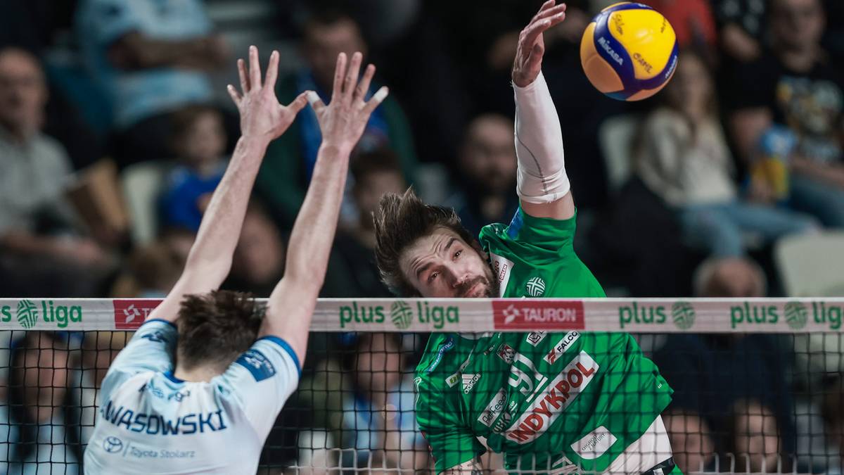 Siatkarz w zielonej koszulce Indykpol AZS Olsztyn wykonuje atak, blokuje go zawodnik w białej koszulce Cuprum Stilon Gorz&oacute;w.