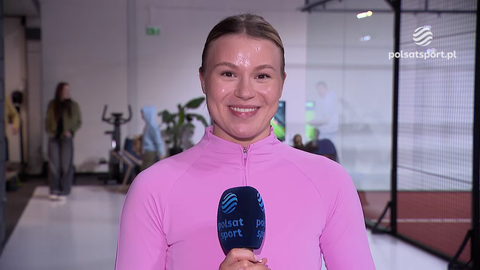 Natalia Maliszewska w r&oacute;żowej bluzce z logo Polsat Sport, uśmiecha się do kamery w centrum treningowym.