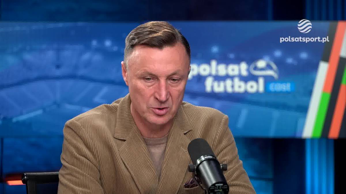 Mężczyzna w brązowej marynarce mówi do mikrofonu na tle studia telewizyjnego z logo Polsat Sport.