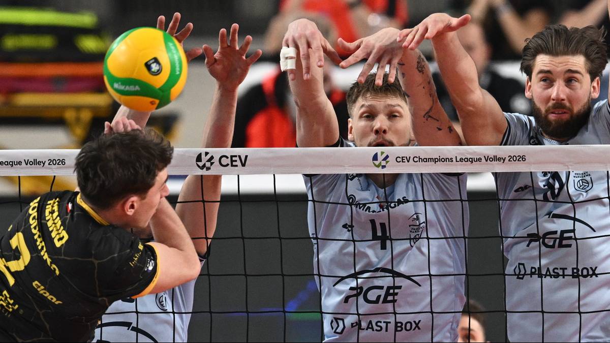 Siatkarze PGE Projekt Warszawa w akcji podczas meczu Ligi Mistrz&oacute;w, blokujący atak przeciwnika.