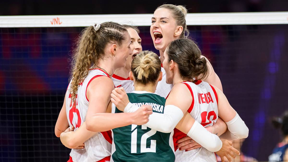 Pięć siatkarek w białych i zielonych strojach otacza się ramionami, celebrując zwycięstwo. Jedna z nich krzyczy z radości, a pozostałe uśmiechają się i patrzą na siebie.