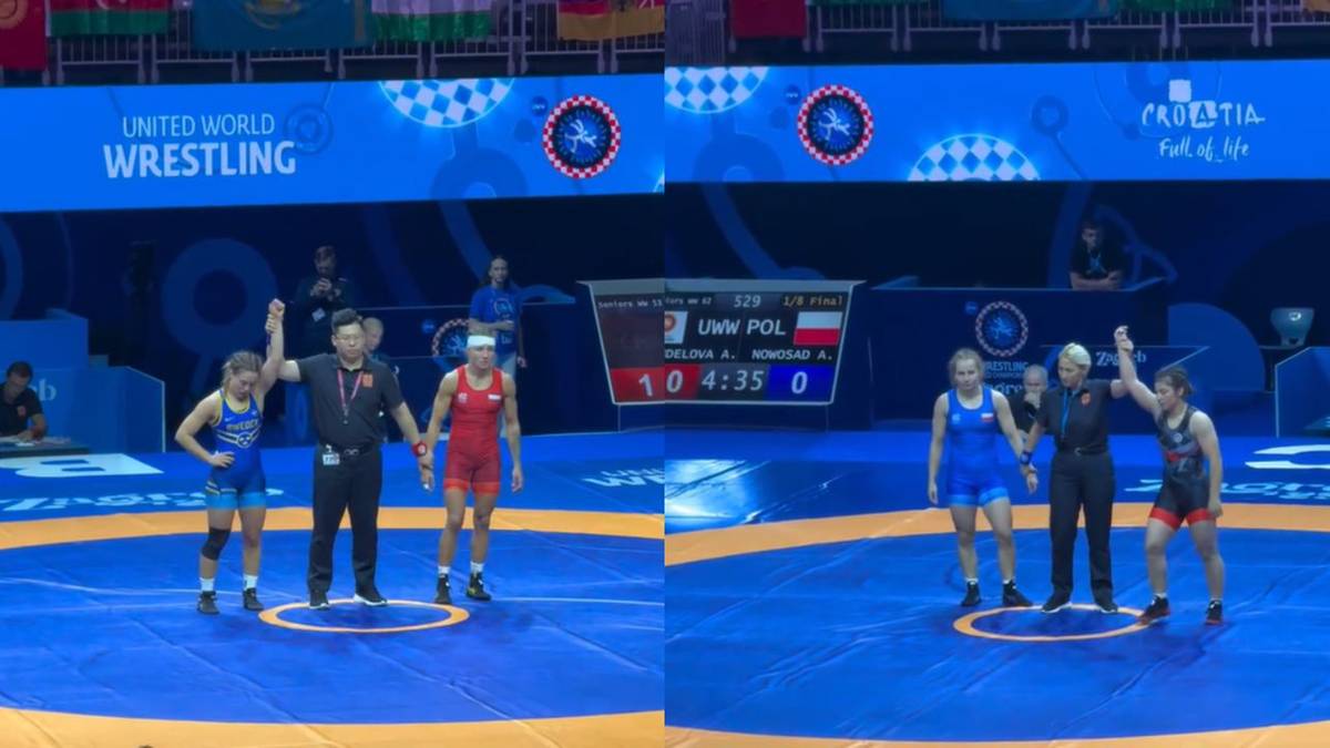 Dwie wrestlerki stoją na macie w niebieskich i czerwonych strojach. Trener i sędzia podnoszą ręce zwycięskim zawodniczkom. Na ekranie widnieje wynik.