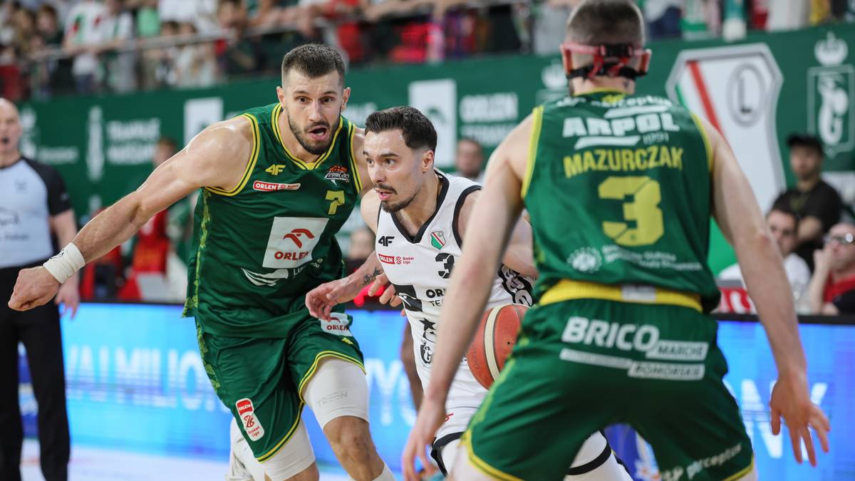 Trzech koszykarzy podczas meczu finałowego Orlen Basket Ligi, dw&oacute;ch w zielonych strojach pr&oacute;buje odebrać piłkę zawodnikowi w białym stroju.