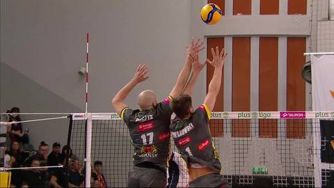 Dw&oacute;ch siatkarzy w skoku, blokujących piłkę podczas meczu siatk&oacute;wki.