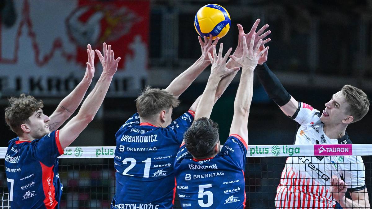 Czterech siatkarzy podczas meczu, dwóch z nich próbuje zablokować atak przeciwnika.