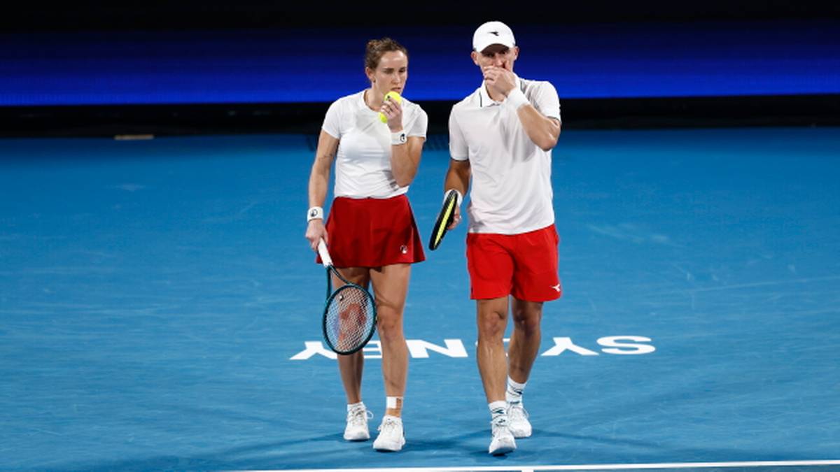 Dwóch tenisistów, kobieta i mężczyzna, na korcie tenisowym.