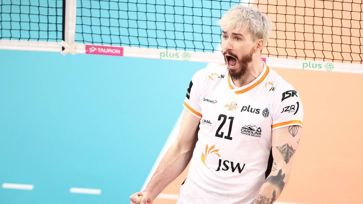 Siatkarz Tomasz Fornal w białej koszulce z numerem 21, z blond włosami i zarostem, krzyczy podczas meczu siatk&oacute;wki.