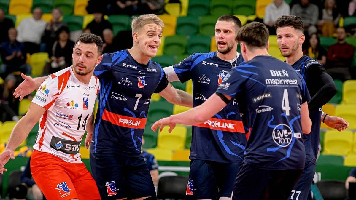 Siatkarze w akcji podczas meczu siatkówki w hali sportowej.