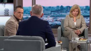 Trzy osoby siedzą na kanapach w studiu telewizyjnym. Dwie osoby siedzą przodem do widza, a jedna tyłem. W tle widać panoramę miasta przez okno.