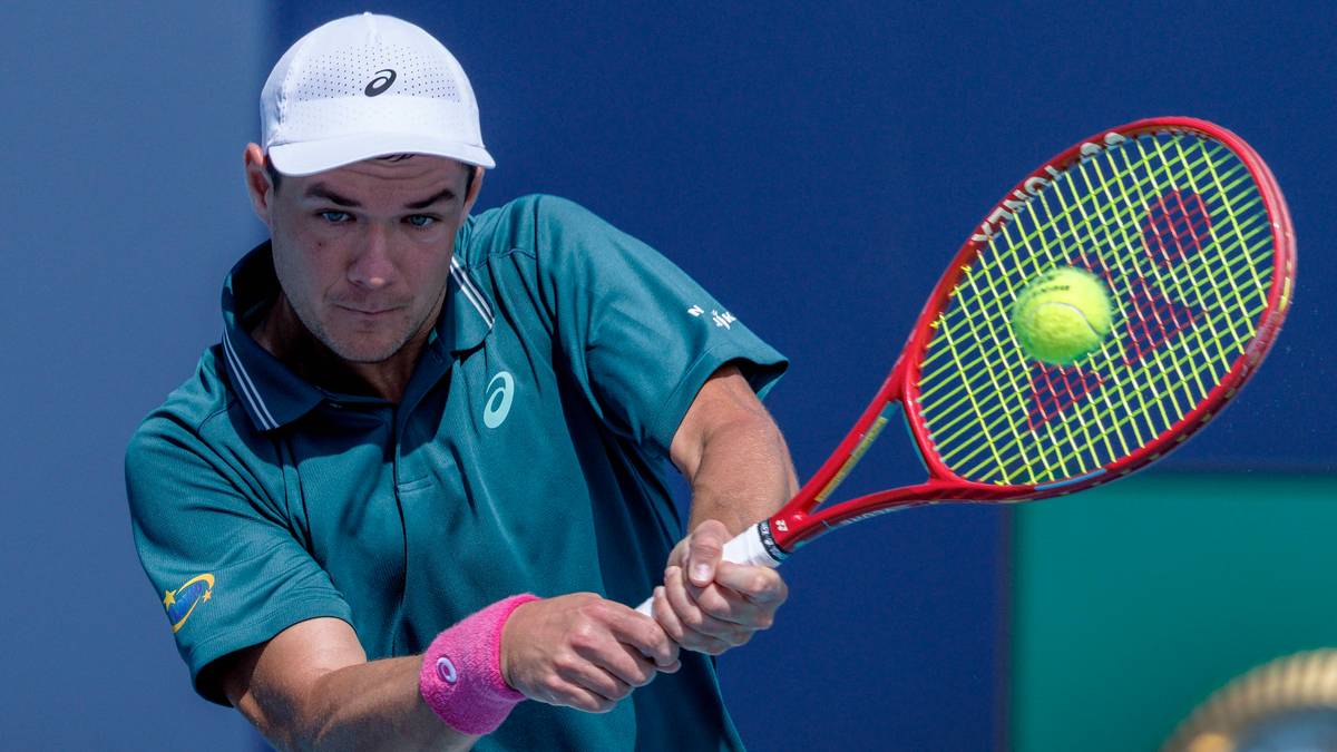 Tenisista Kamil Majchrzak uderza piłkę rakietą podczas meczu.