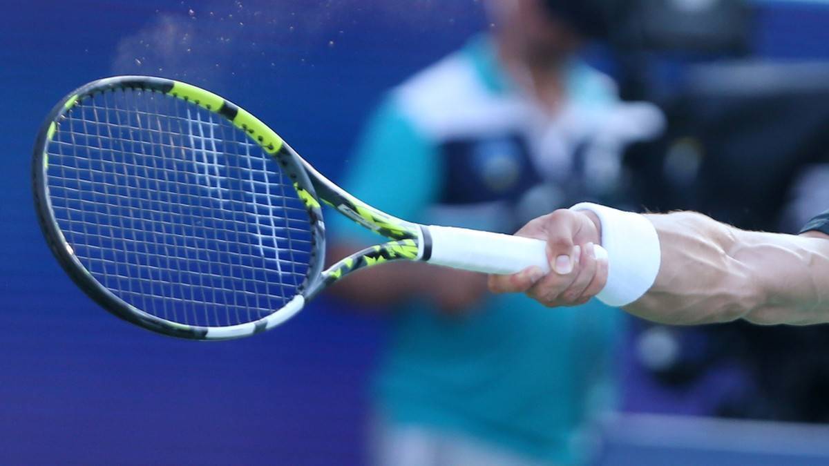 Ręka tenisisty trzymająca rakietę tenisową.