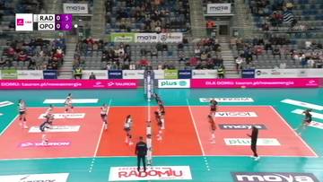 Mecz siatk&oacute;wki pomiędzy drużynami Moya Radomka Radom i UNI Opole. Widoczni zawodnicy na boisku w trakcie akcji, siatka, trybuny wypełnione widzami.