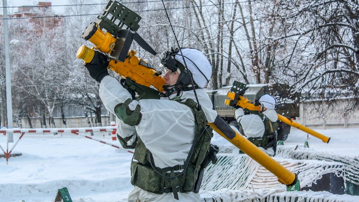 Żołnierz w zimowym kamuflażu przygotowuje przenośną wyrzutnię rakietową.