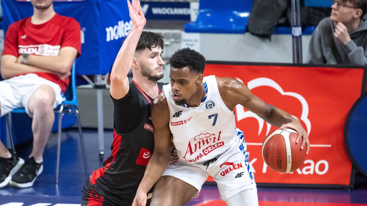 Dwóch koszykarzy walczy o piłkę podczas meczu, zawodnik Anwilu z piłką w rękach.