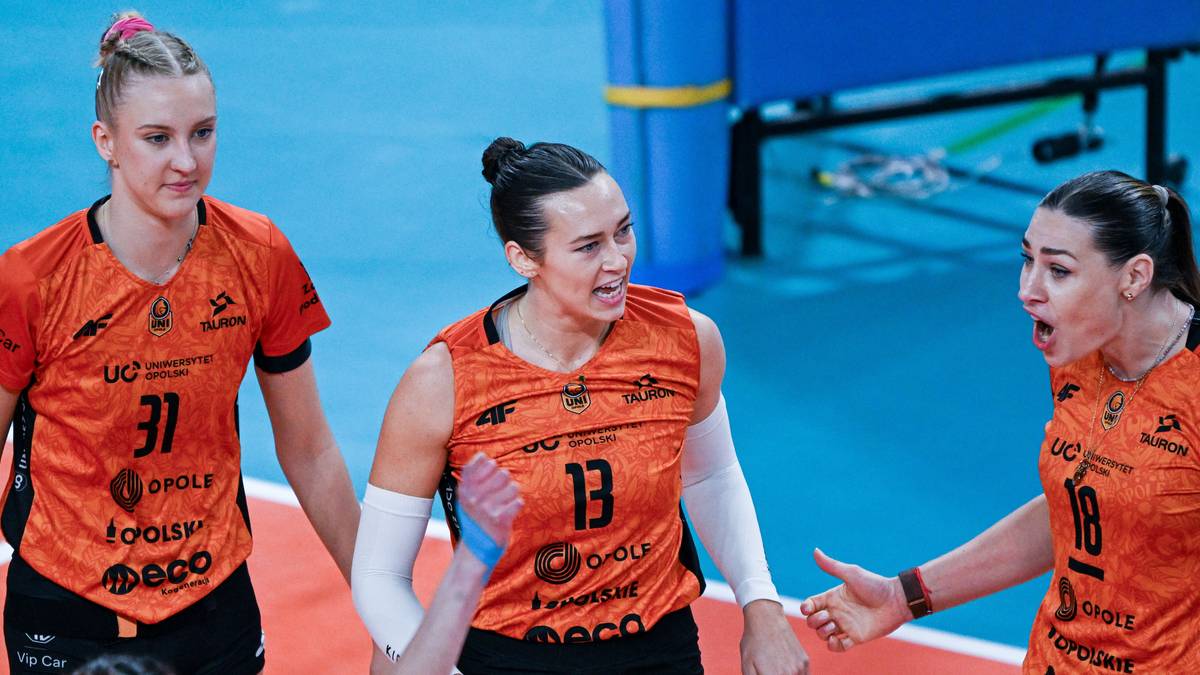 Cztery siatkarki w pomarańczowych strojach na boisku do siatkówki.