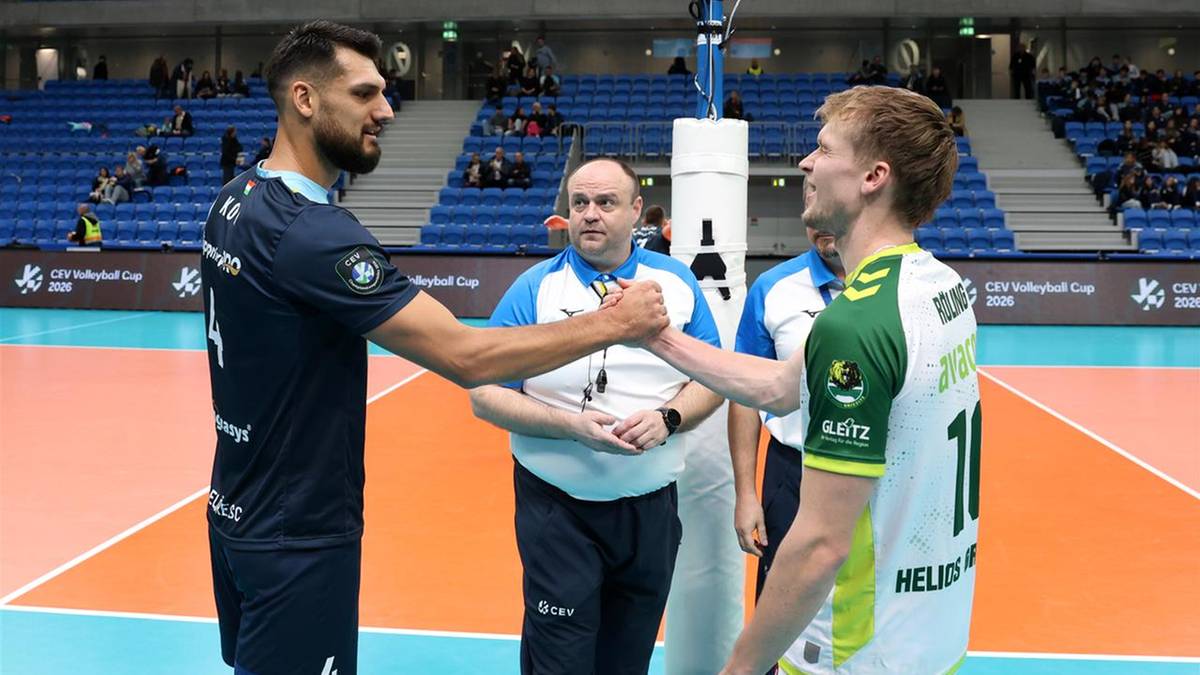 Dwóch siatkarzy i sędzia na boisku siatkarskim.