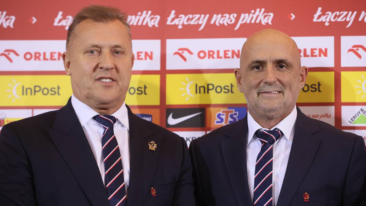 Dwóch mężczyzn w garniturach, jeden starszy po lewej, drugi łysy po prawej, stoją przed czerwono-białym tłem z logotypami.