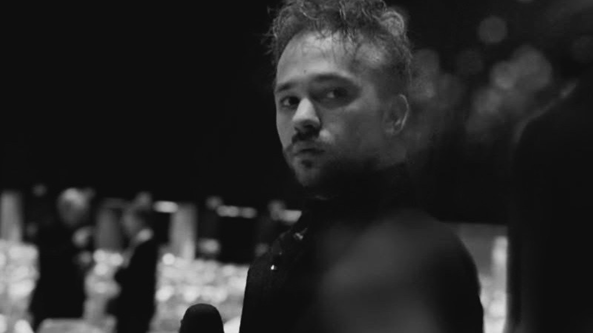 Portret Kryspina Sandaka, dziennikarza TVP3 Katowice, w czarno-białym ujęciu.