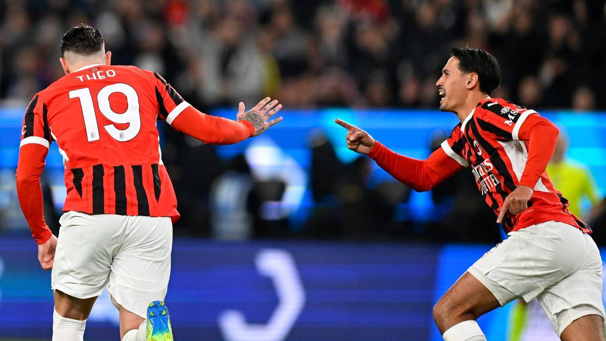 Dwóch piłkarzy w czerwono-czarnych strojach piłkarskich na boisku.