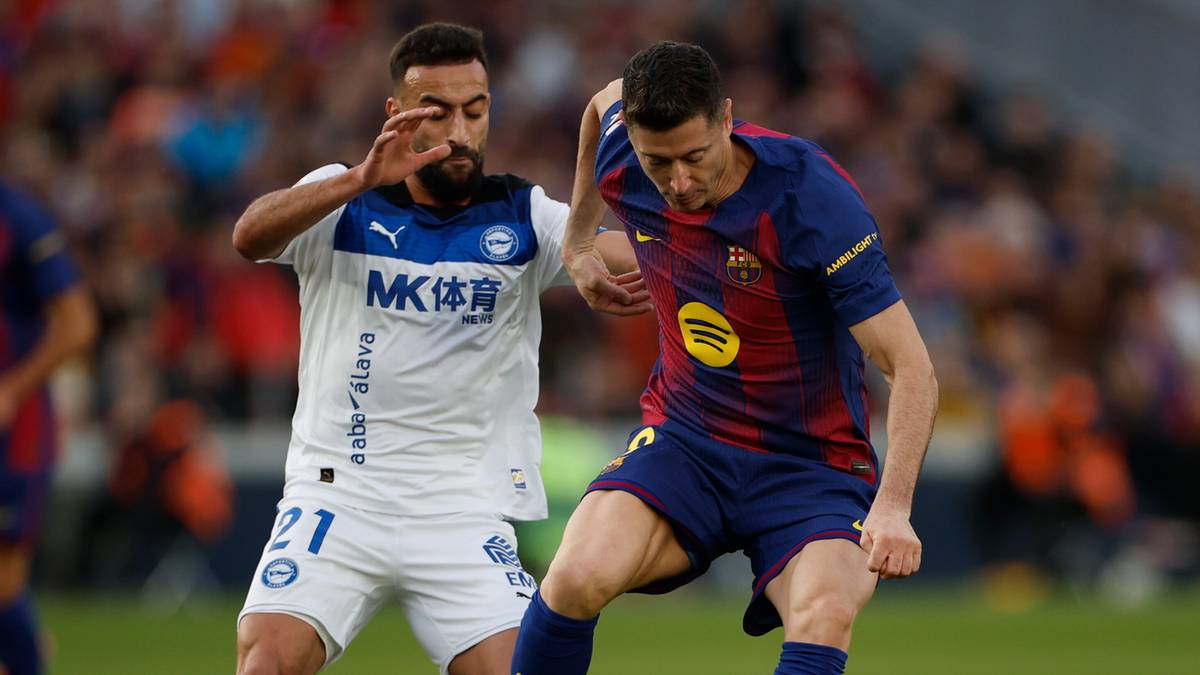 Piłkarz FC Barcelony Robert Lewandowski walczy o piłkę z zawodnikiem drużyny przeciwnej.