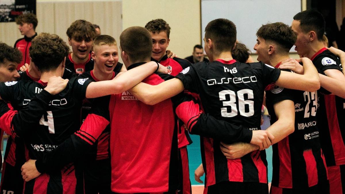 Siatkarze w strojach sportowych przytulają się w geście wsparcia.