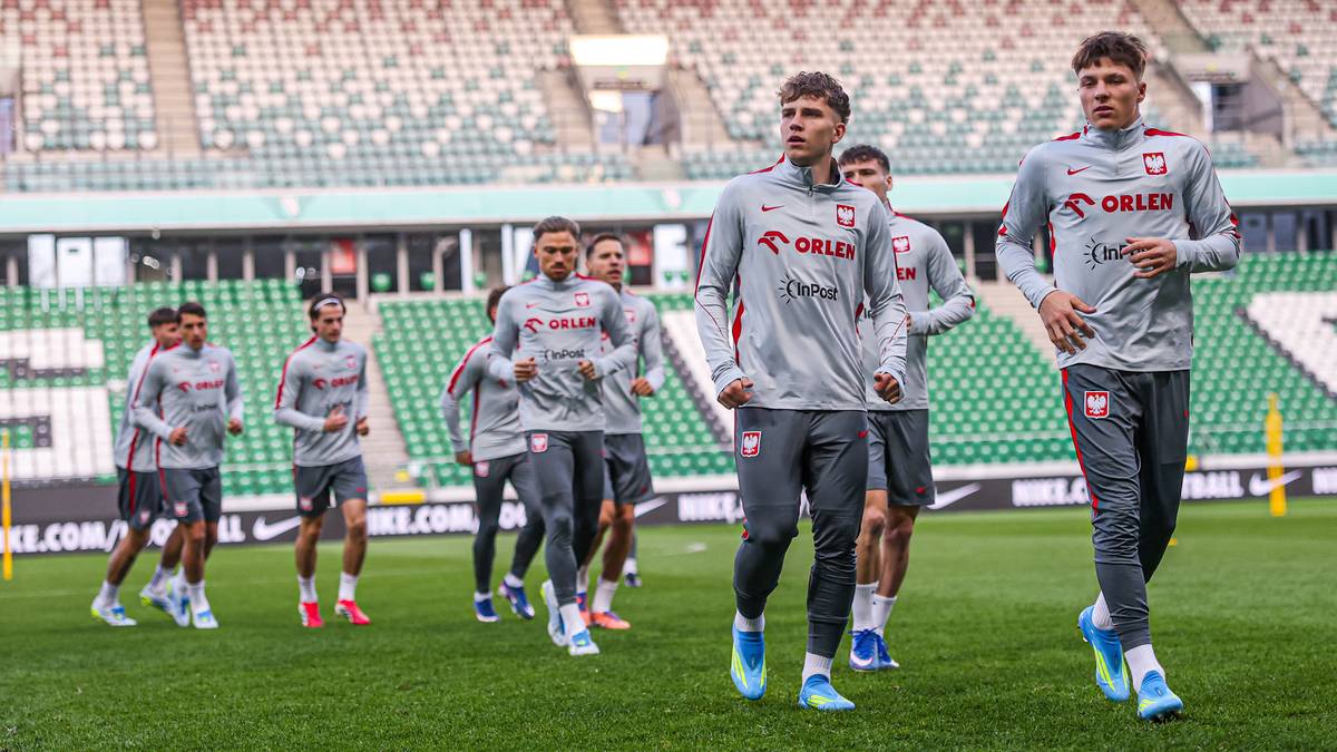Piłkarze reprezentacji Polski w strojach treningowych na murawie stadionu.