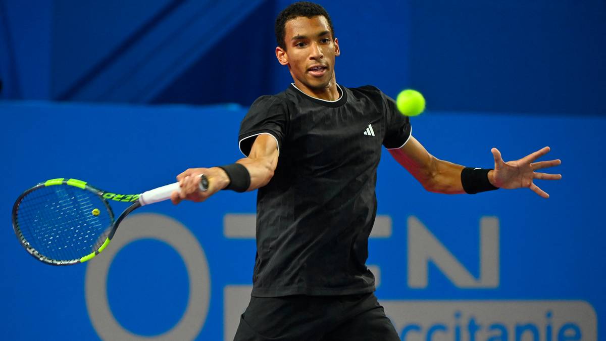 Tenisista Adrian Mannarino odbija piłkę rakietą podczas meczu.