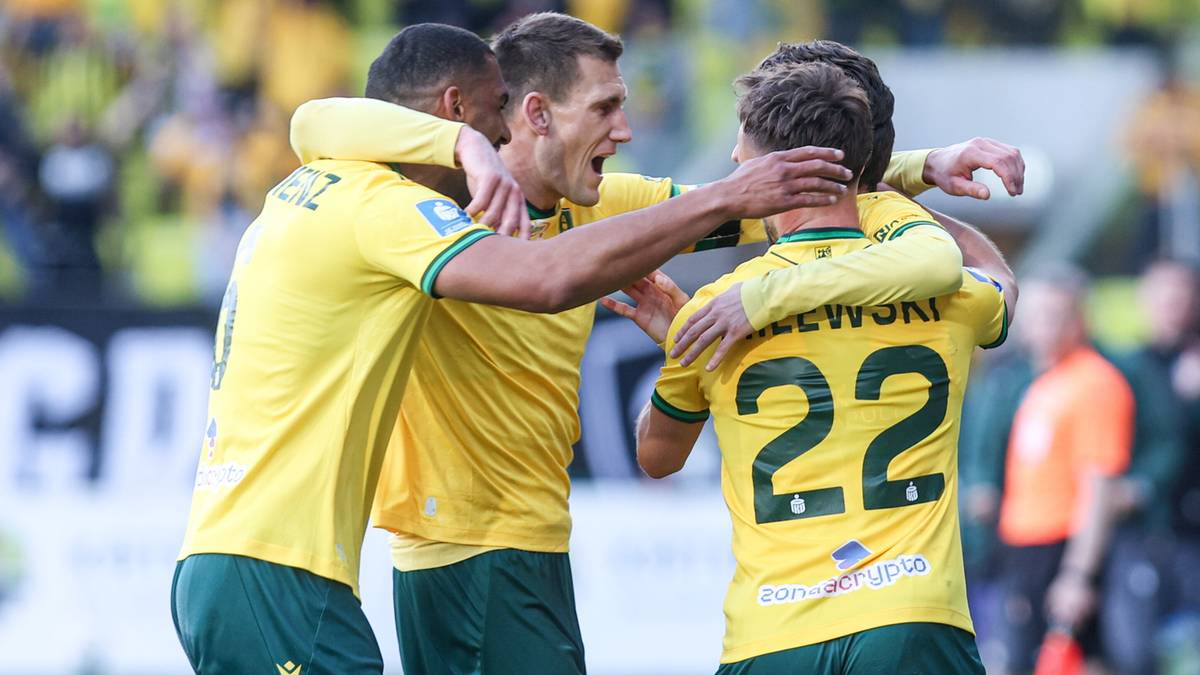 Trzech piłkarzy w ż&oacute;łtych koszulkach celebruje zdobycie bramki, obejmując się nawzajem.