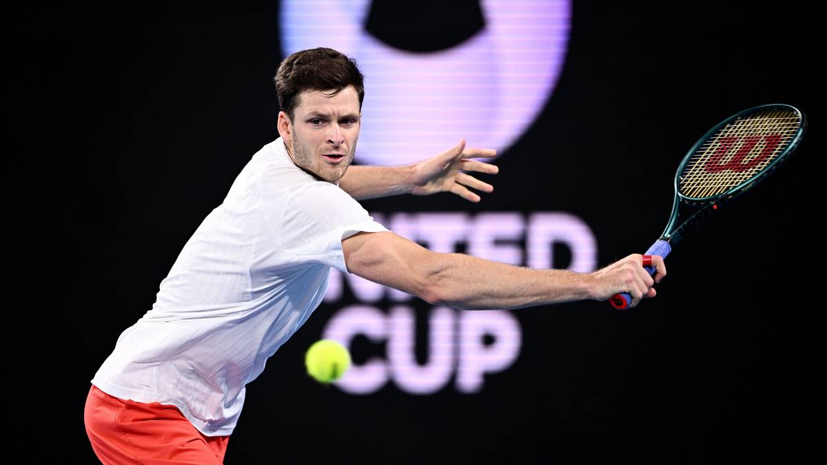 Hubert Hurkacz podczas meczu tenisowego, uderza piłkę rakietą.